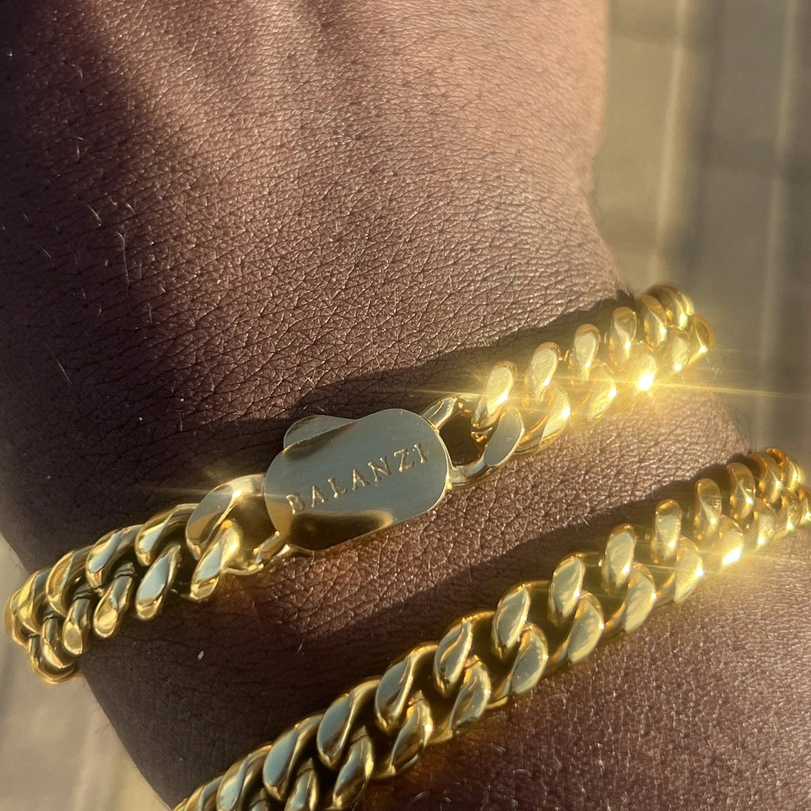 BALANZI Cuban link bracelets stacked on the wrist — golden hour